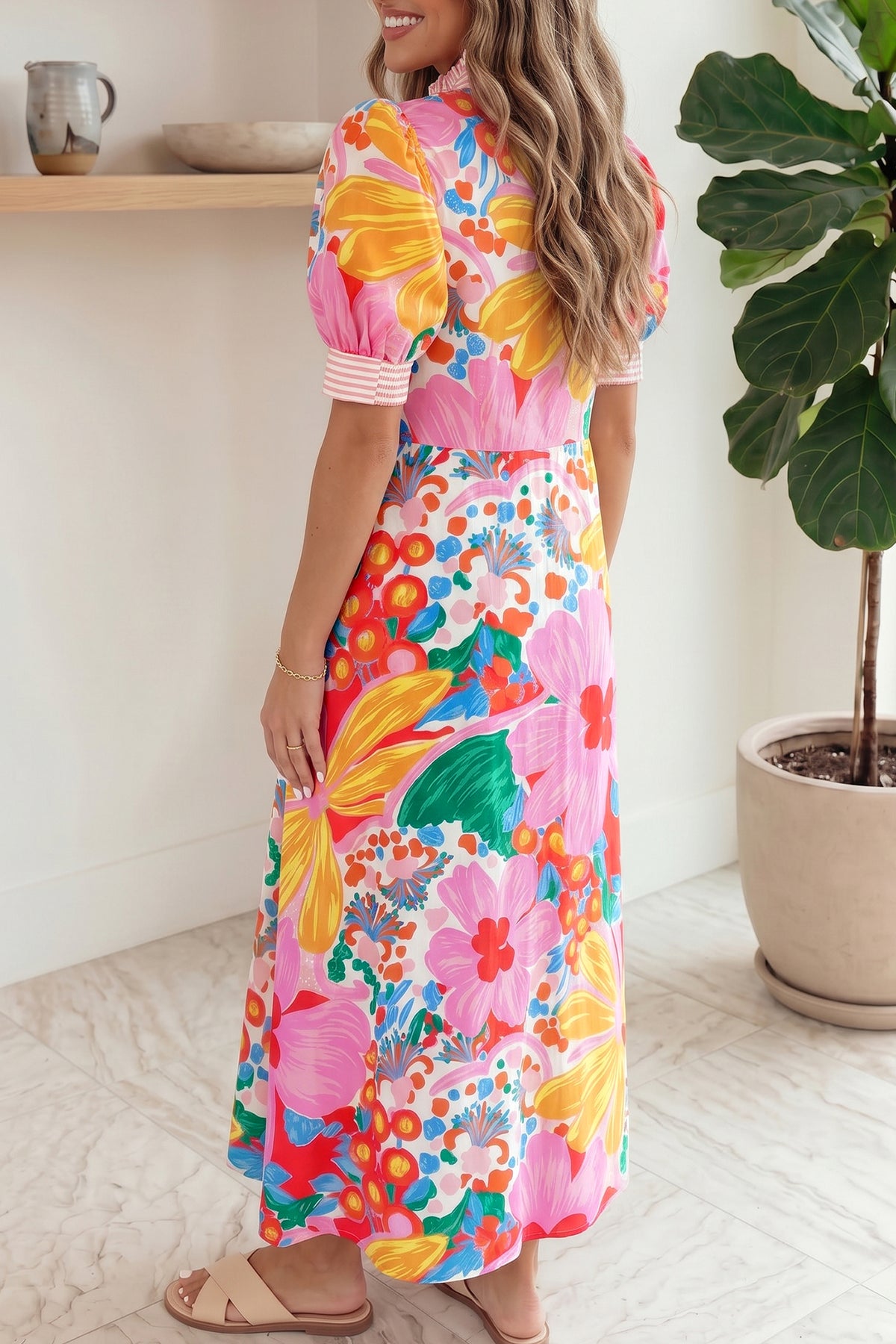 Robe longue à col montant, vue de profil, imprimé fleuri multicolore, manches courtes bouffantes, boutons.