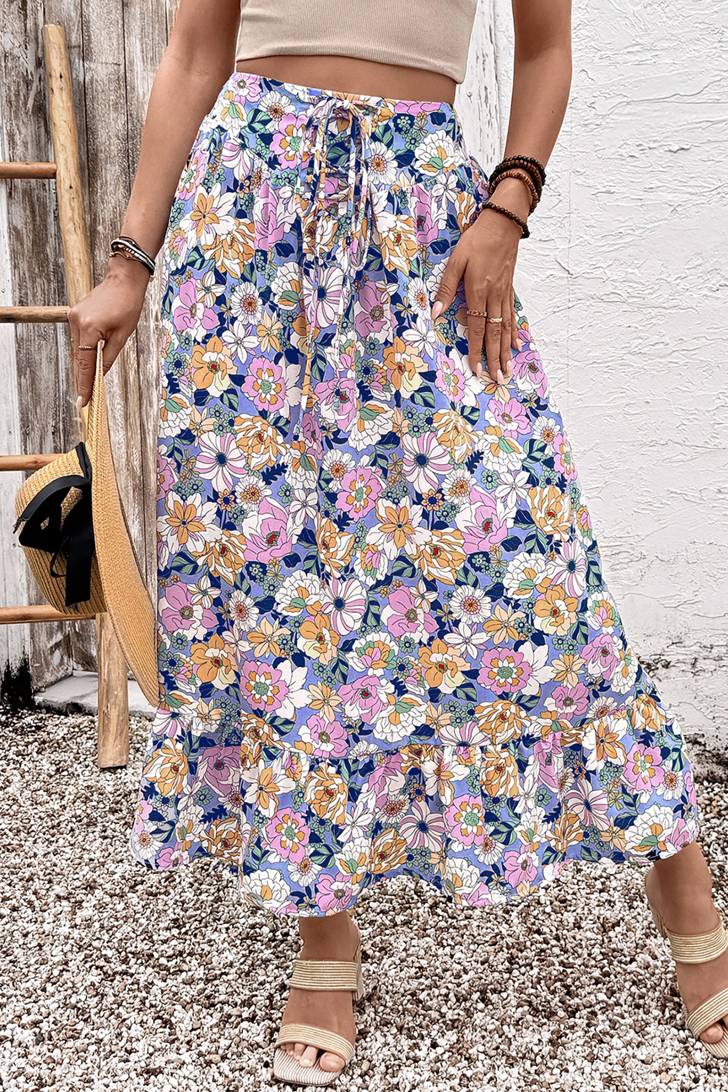 Jupe longue bohème à taille haute, imprimé floral multicolore, volants en cascade.