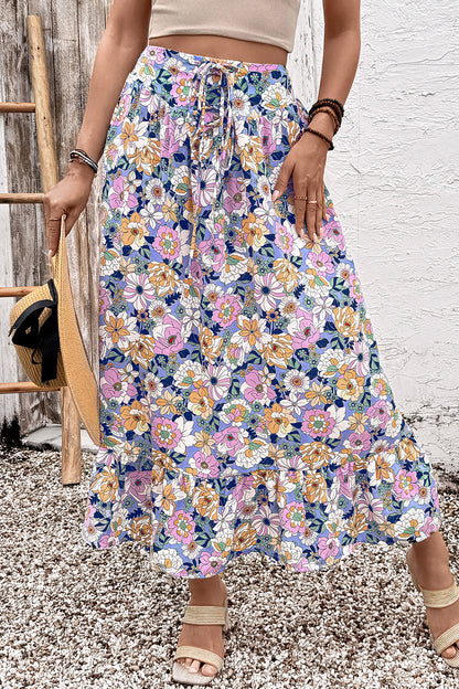 Jupe longue bohème à taille haute, imprimé floral multicolore, volants en cascade.