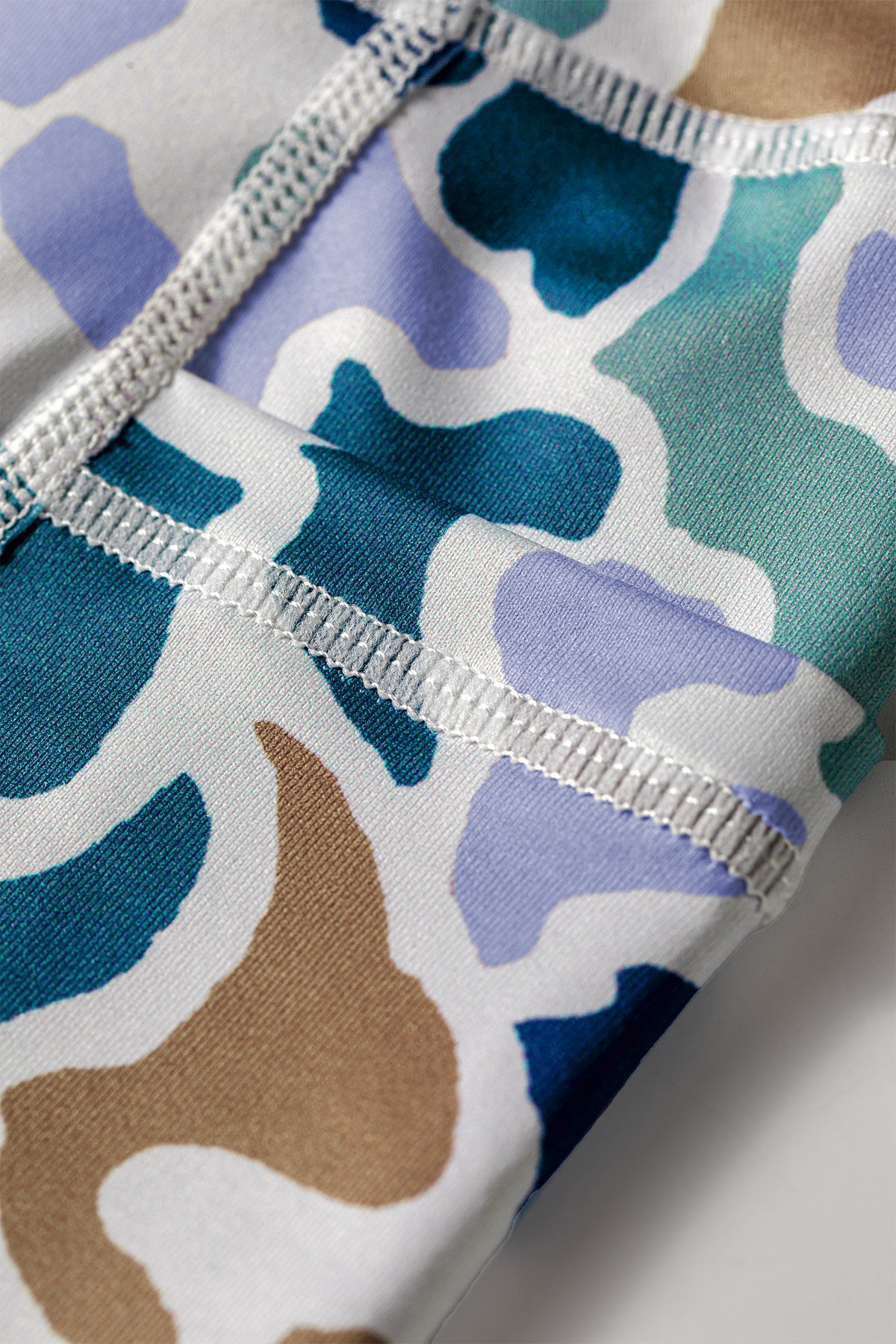 Taille élastique et couture sur short cycliste imprimé camouflage bleu et turquoise.