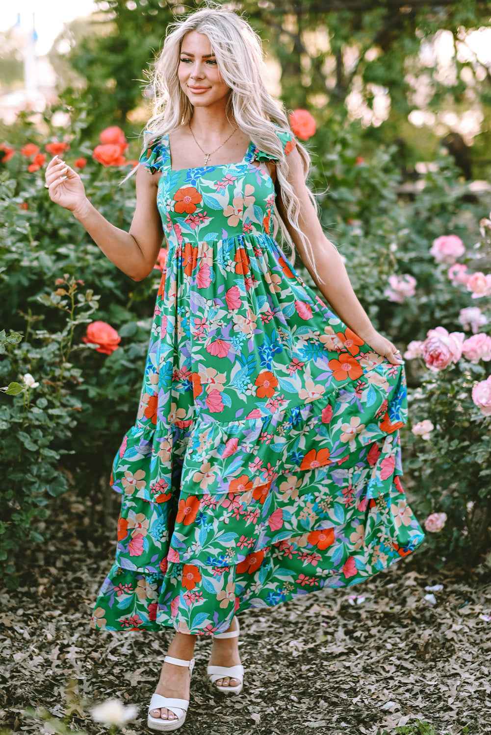 Robe longue verte à fleurs multicolores, buste froncé, volants et coupe A-line évasée.