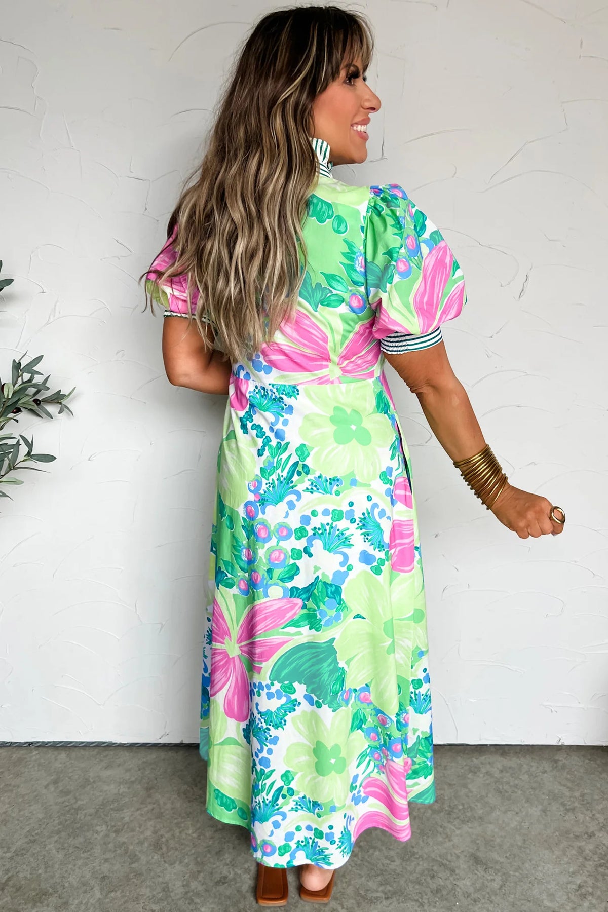 Robe longue imprimée multicolore, vue de côté, col montant rayé, manches courtes bouffantes, boutons.