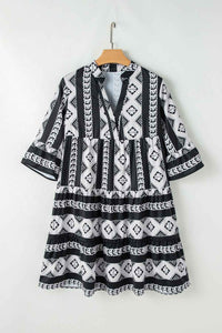 Robe noire à motifs géométriques, col V, manches évasées à volants