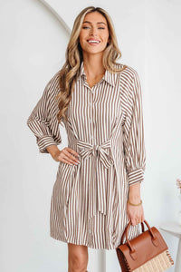 Robe chemisier rayée brune, nœud à la taille, manches bouffantes, boutonnée.