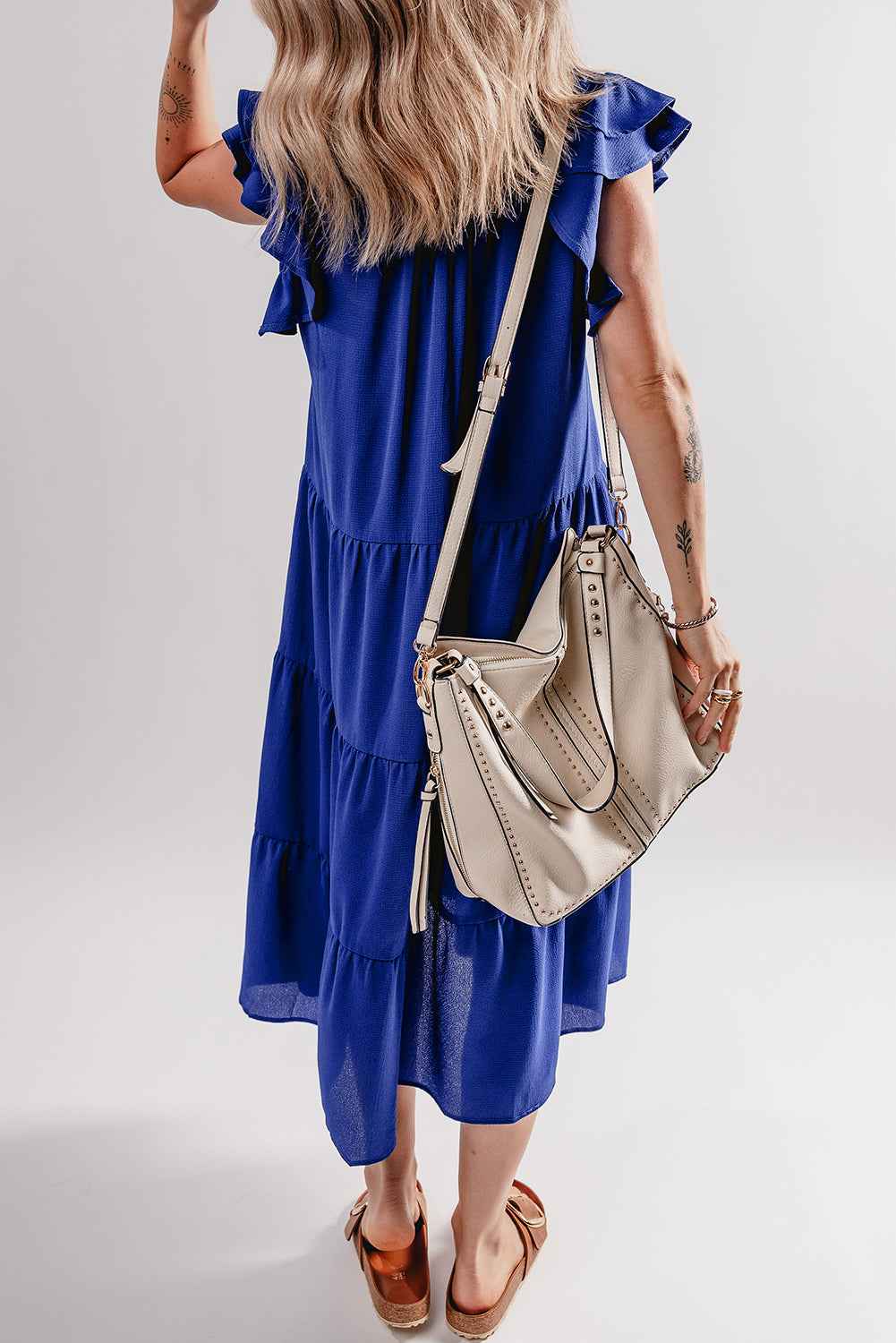 Robe midi bleue manches volantées et encolure V, empiècements à volants étagés.