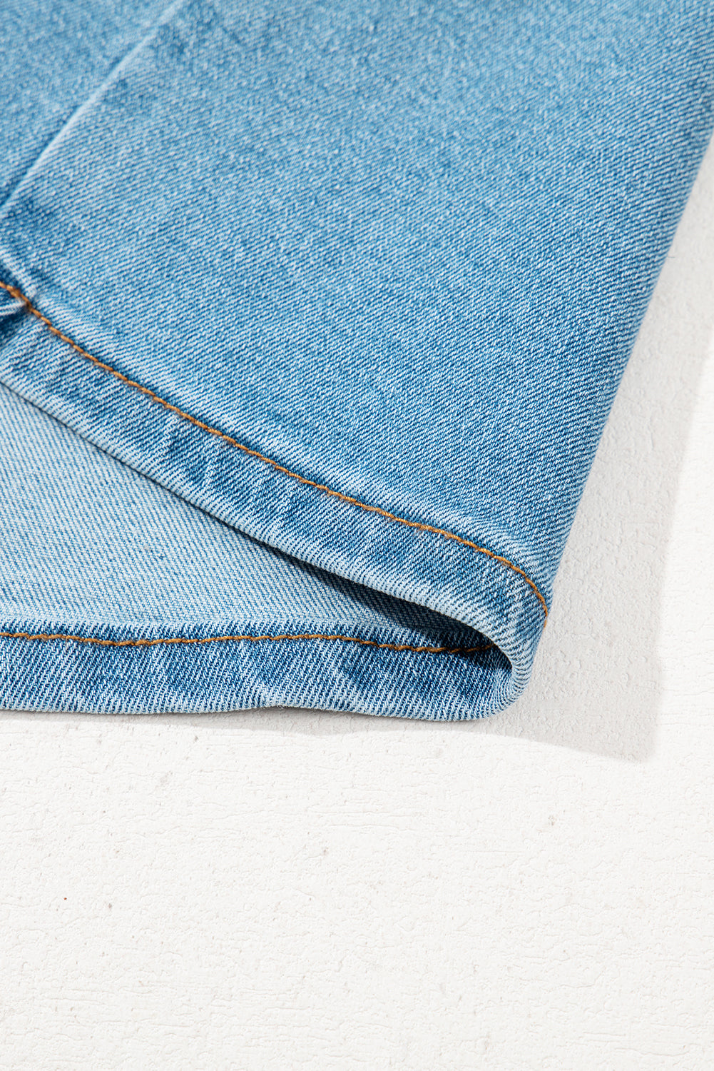 Ourlet de jupe en jean bleu clair, bord inférieur avec coutures visibles