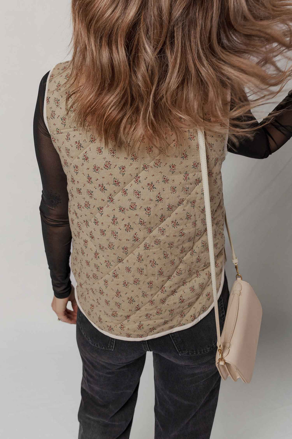 Veste matelassée beige à motif floral, coutures visibles et bordure blanche, dos fermé
