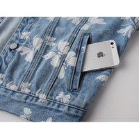 Veste en jean bleue à motif floral blanc, patte de poche et bouton pression