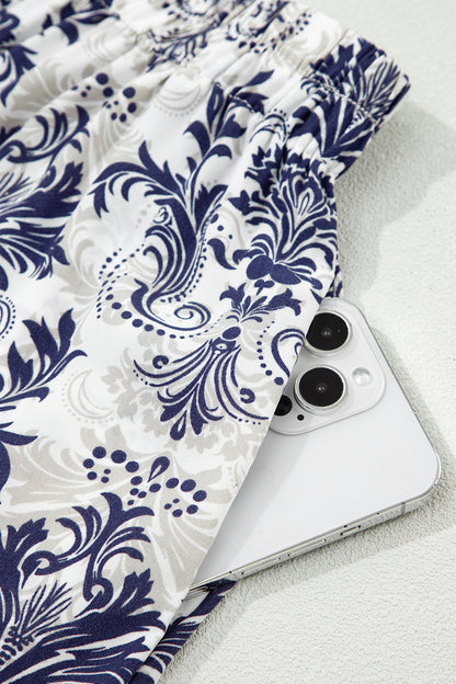 Jupe longue bleu et blanc à motif baroque floral, tissu fluide.