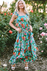 Robe longue verte à fleurs multicolores, encolure carrée, volants et jupe très ample.