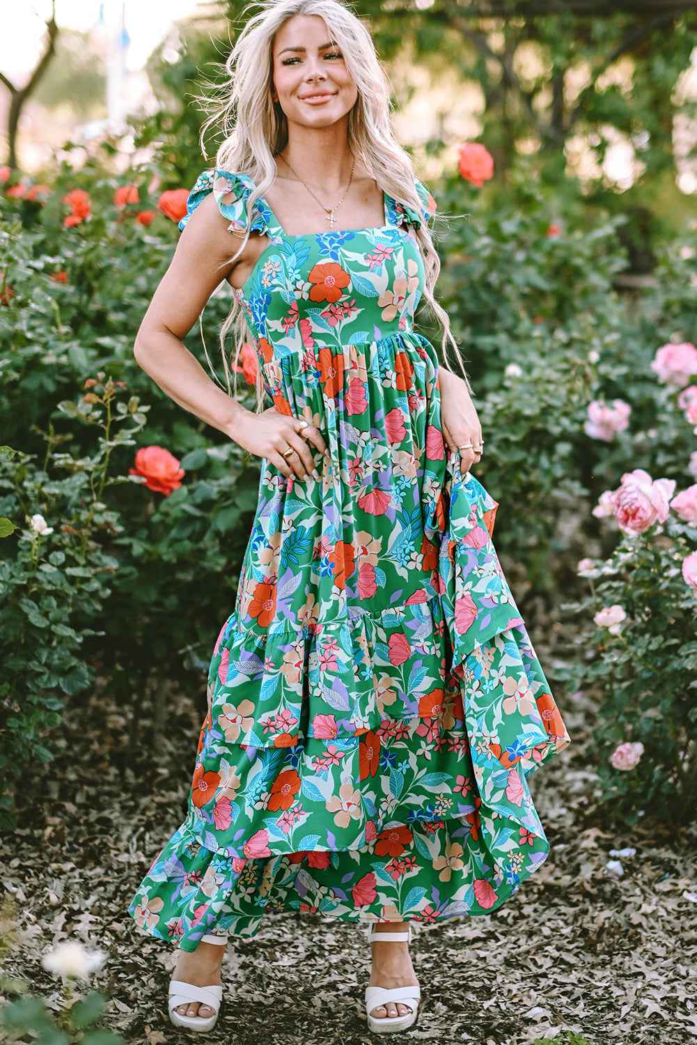 Robe longue verte à fleurs multicolores, encolure carrée, volants et jupe très ample.