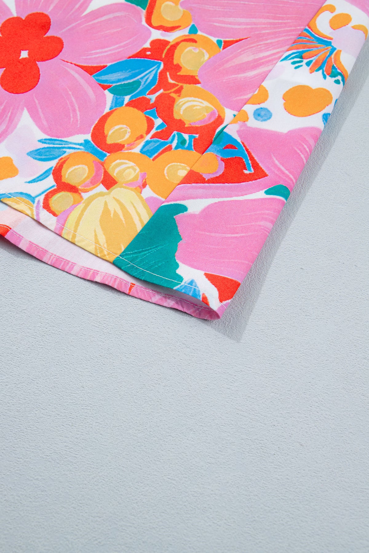 Robe fleurie : gros plan sur le bas de la robe, motifs floraux multicolores.