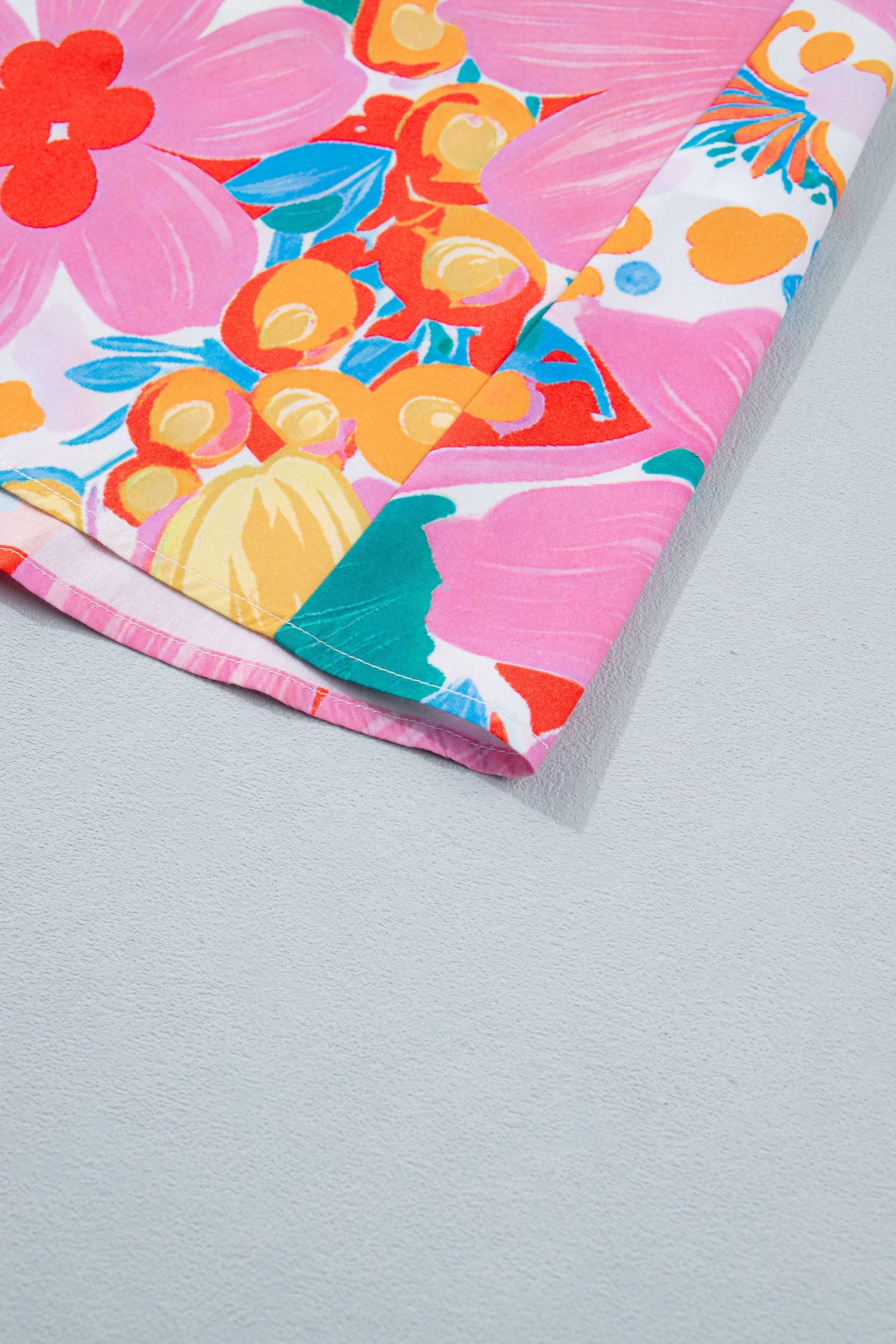 Robe fleurie : gros plan sur le bas de la robe, motifs floraux multicolores.