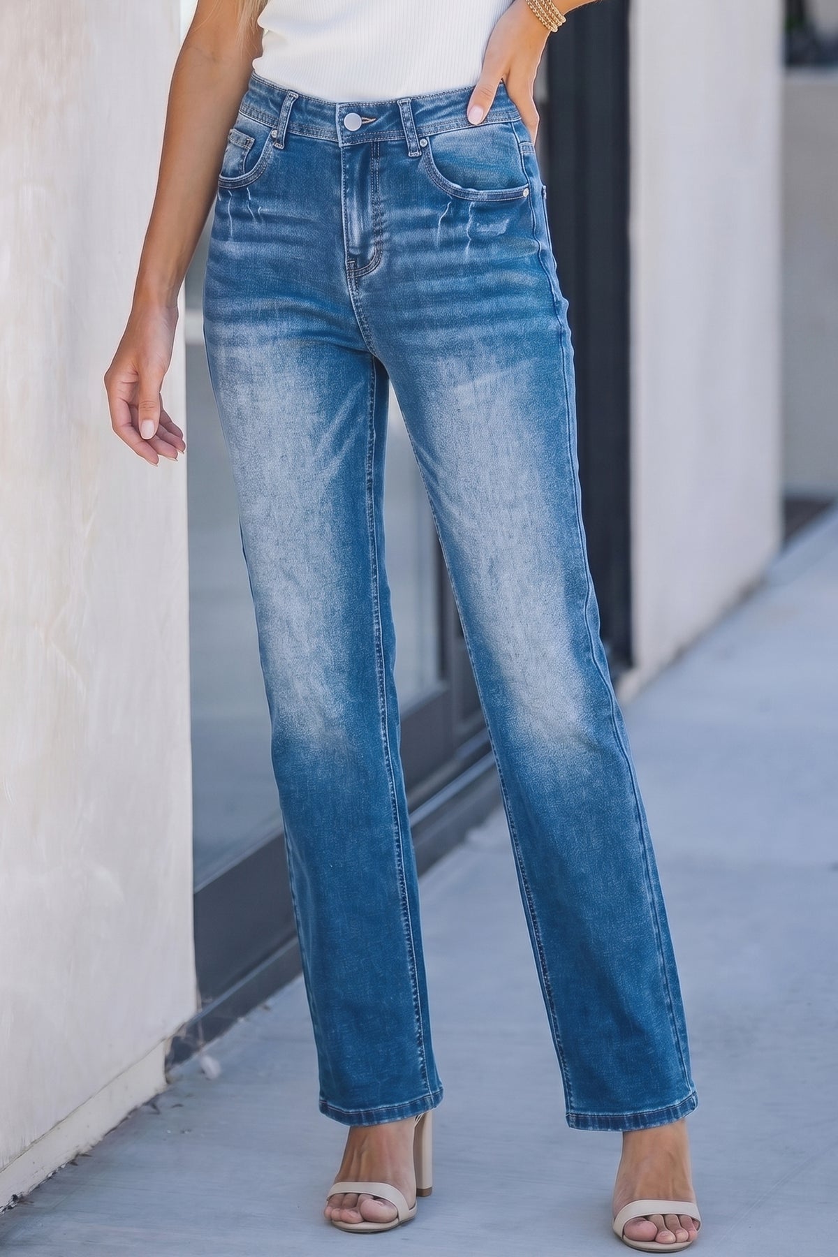 Jean femme taille haute bleu clair droit, effet délavé, poches et fermeture à bouton.