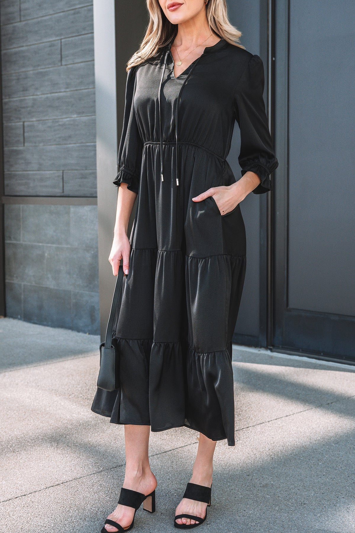 Robe mi-mollet noire à volants étagés, manches bouffantes, encolure V.