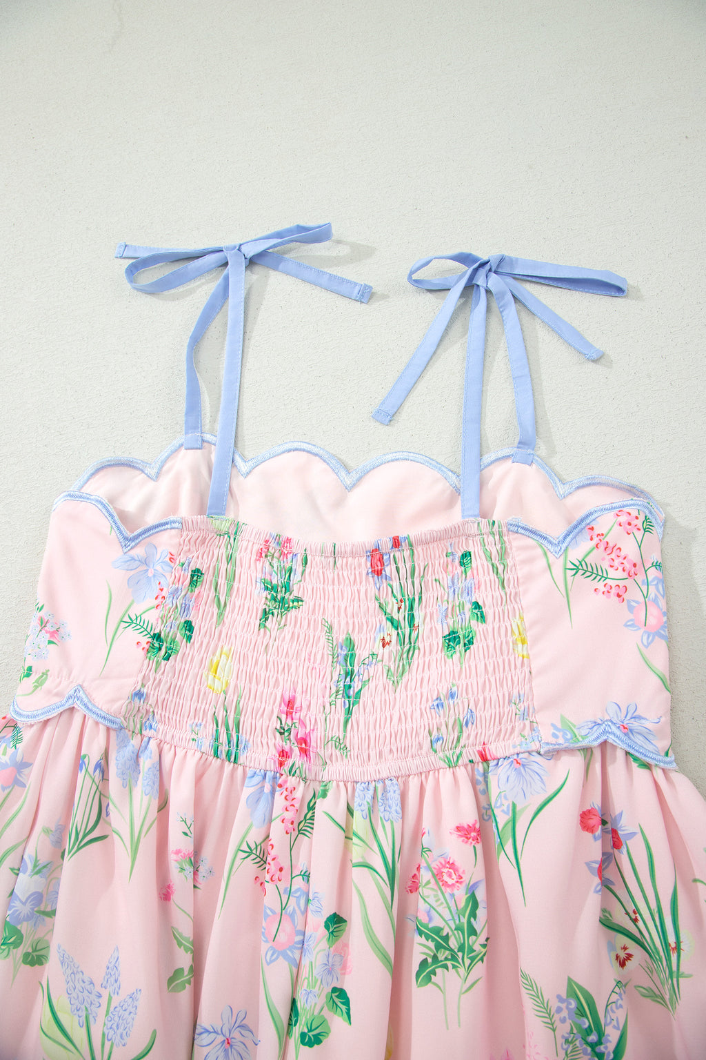 Robe midi rose à bretelles, taille haute, imprimé floral, volants bord bleus.