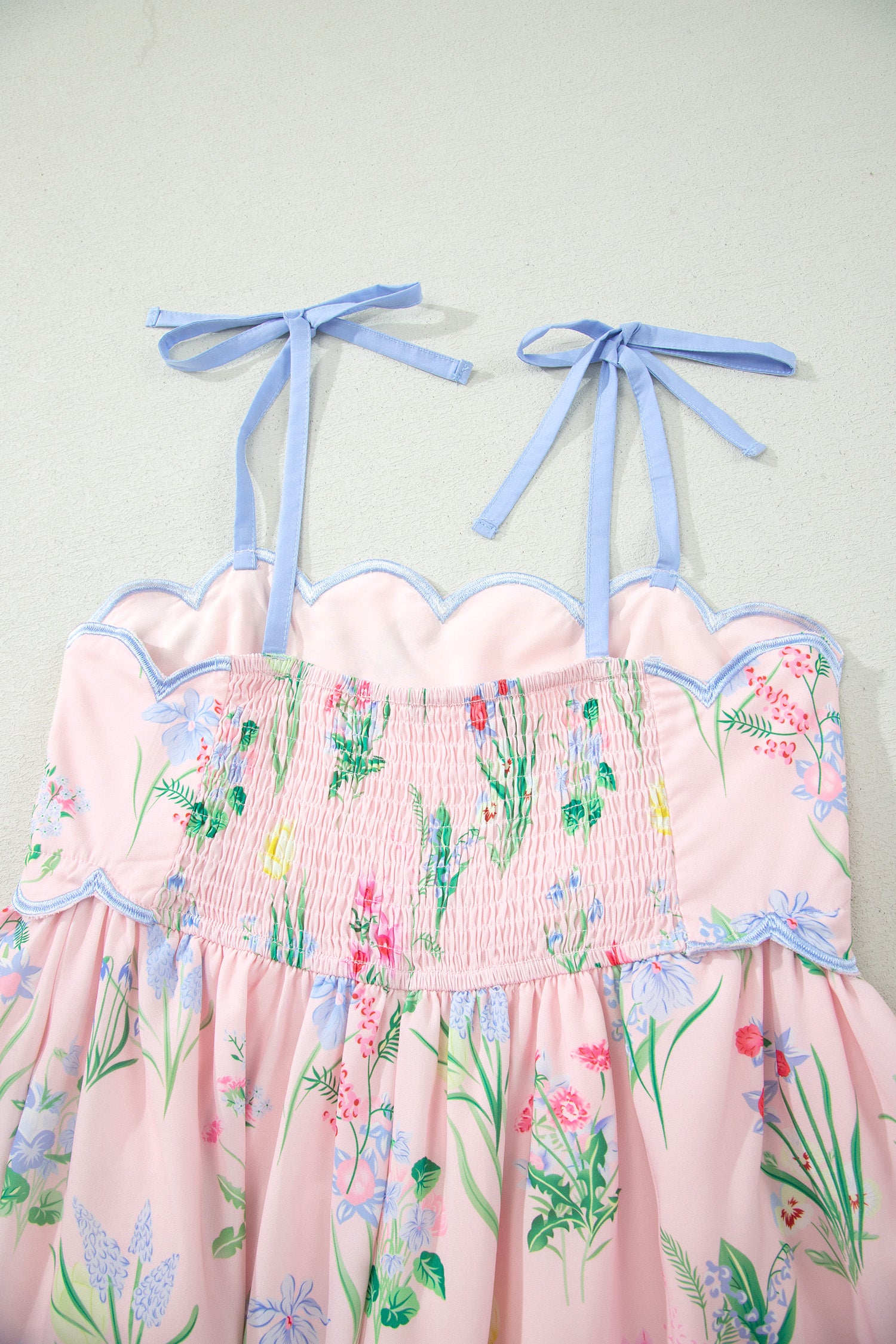 Robe midi rose à bretelles, taille haute, imprimé floral, volants bord bleus.