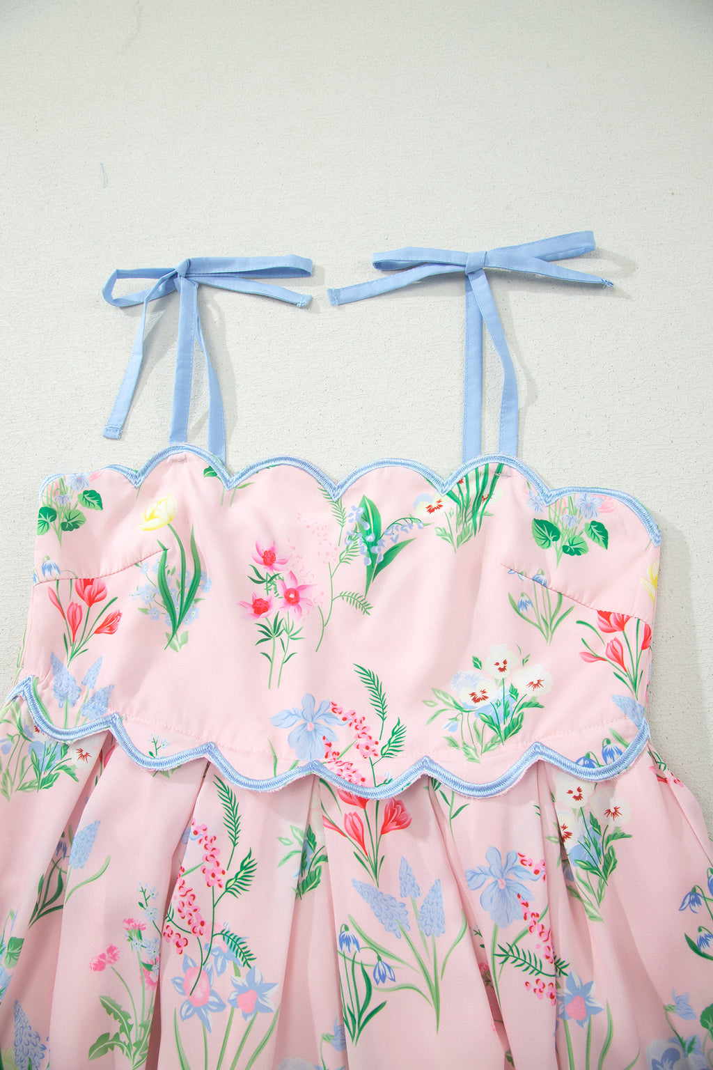 Robe midi rose à bretelles nouées bleues, imprimé floral, jupe évasée.