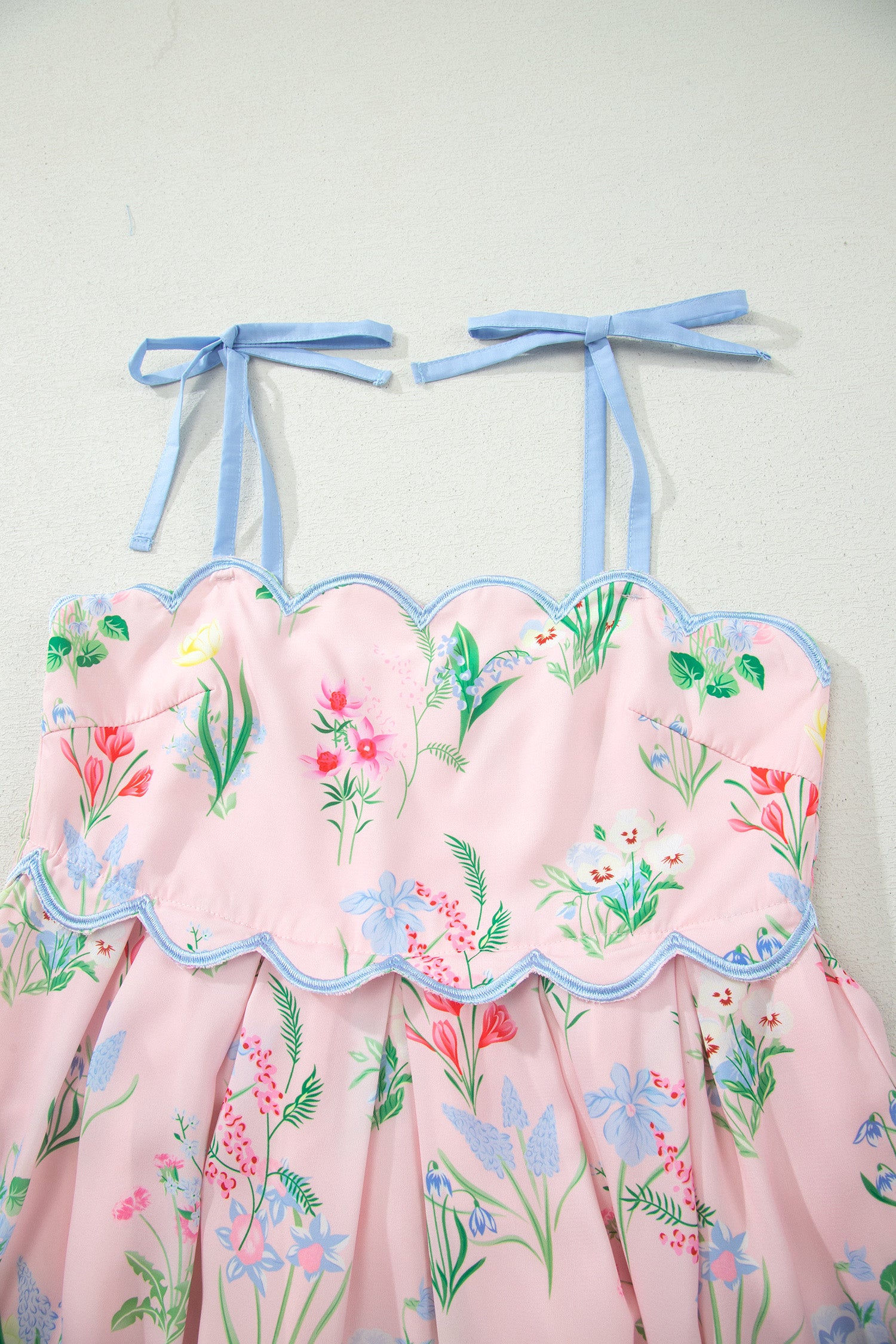 Robe midi rose à bretelles nouées bleues, imprimé floral, jupe évasée.