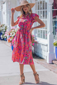 Robe longue fuchsia fleurie, ceinture à nouer, manches volantées, coupe A-line.