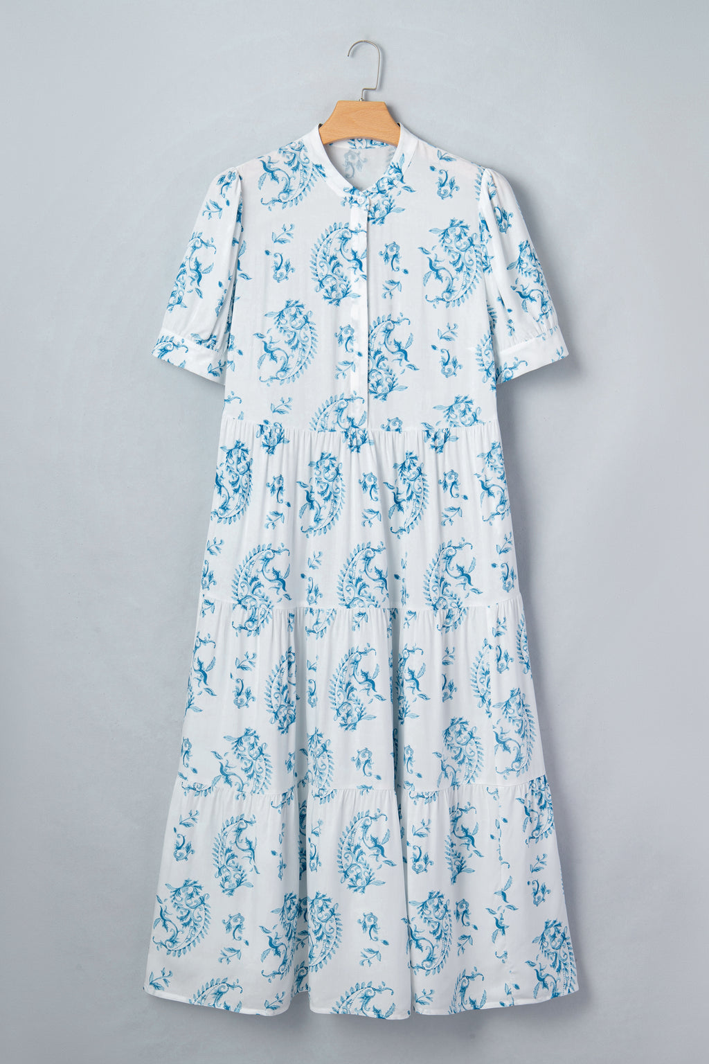 Robe maxi bleu ciel à fleurs sur cintre, encolure boutonnée et manches courtes bouffantes.