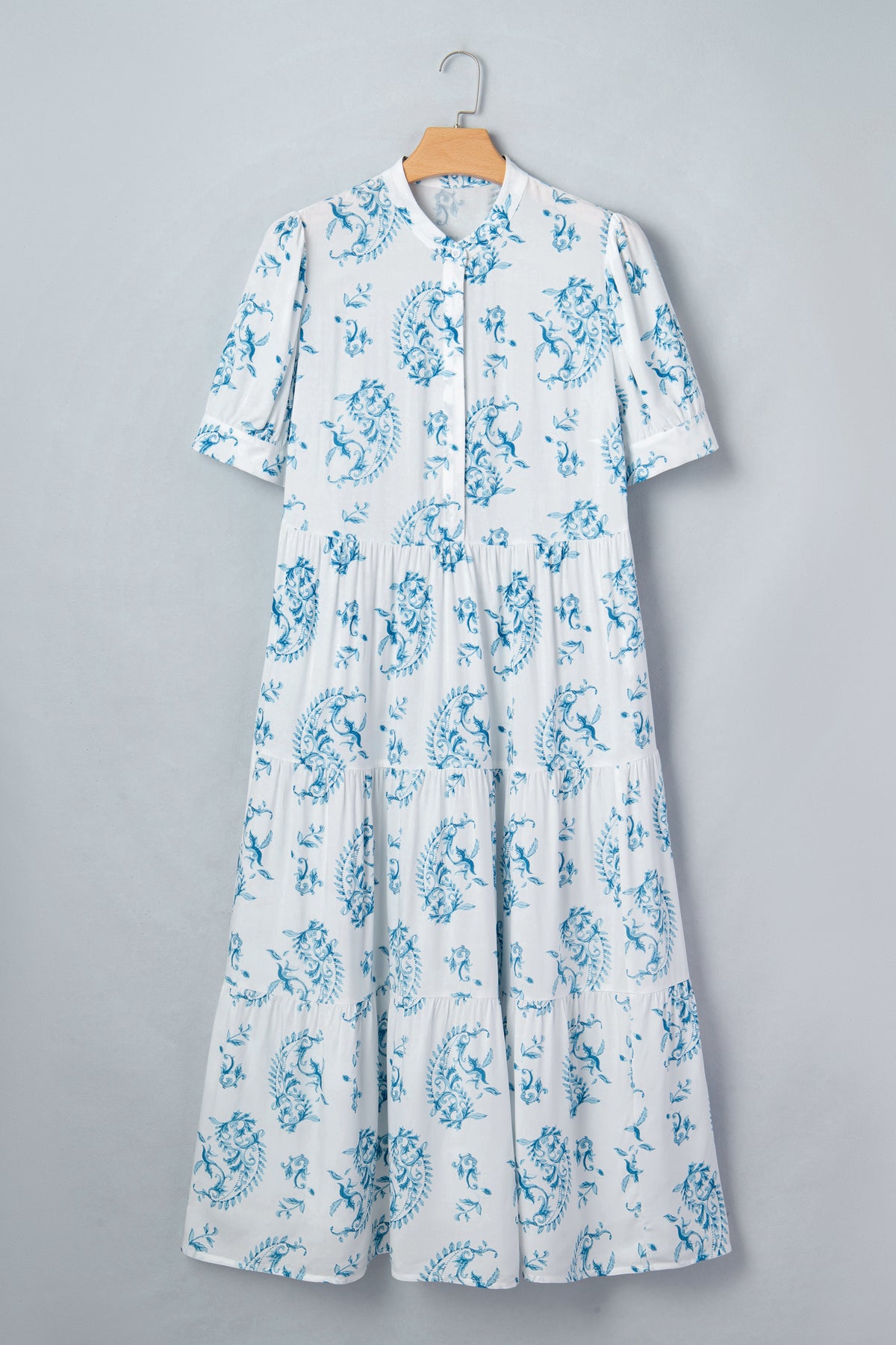 Robe maxi bleu ciel à fleurs sur cintre, encolure boutonnée et manches courtes bouffantes.
