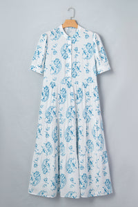 Robe maxi bleu ciel à fleurs sur cintre, encolure boutonnée et manches courtes bouffantes.
