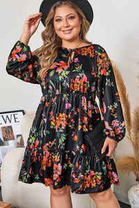 Robe noire à fleurs colorées, col noué, manches longues et taille froncée.