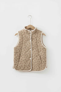 Veste matelassée beige à motif floral sur cintre, col montant, boutons pression, sans manches