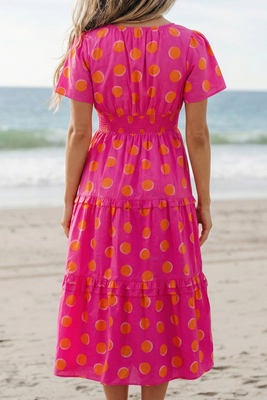 Robe rose à pois jaune, dos échancré en V, volants étagés, longueur midi.