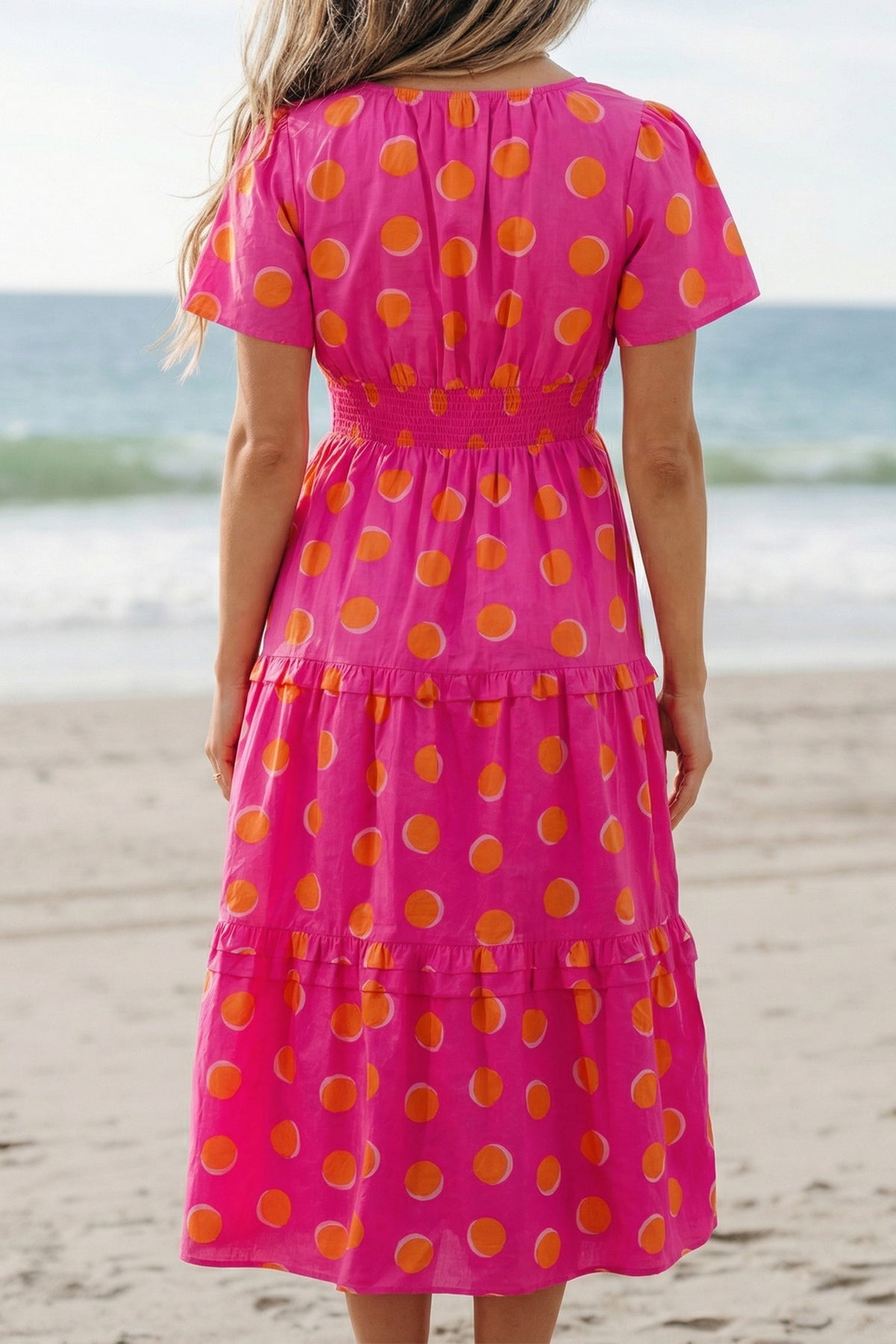 Robe rose à pois jaune, dos échancré en V, volants étagés, longueur midi.