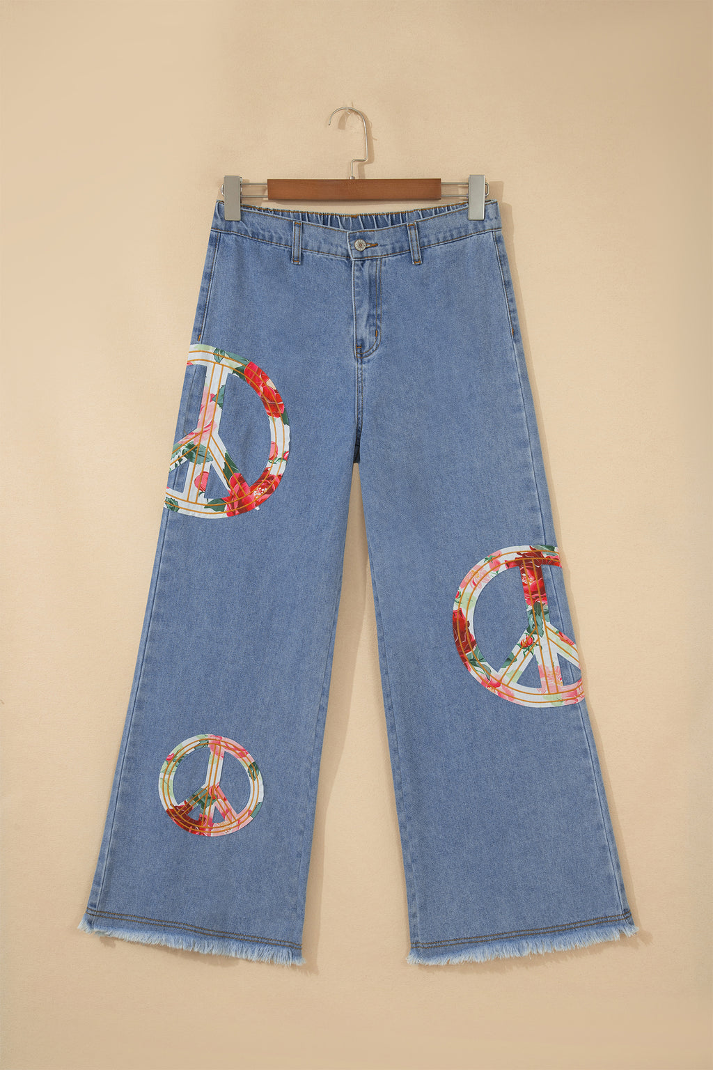 Jean bleu clair ample avec plusieurs patches floraux signe de la paix