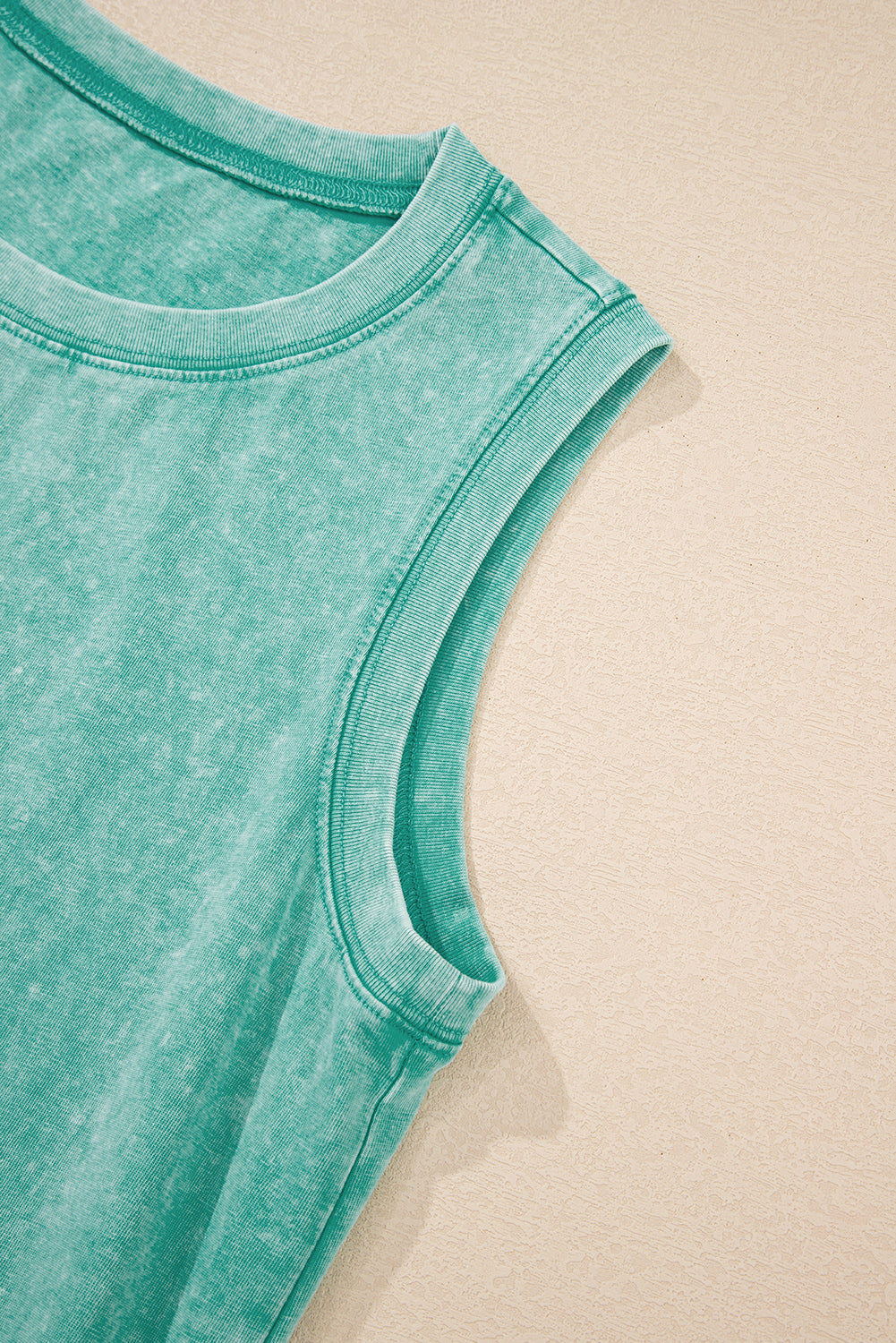 Détail robe mini verte sans manches : encolure ronde et bordures cousues