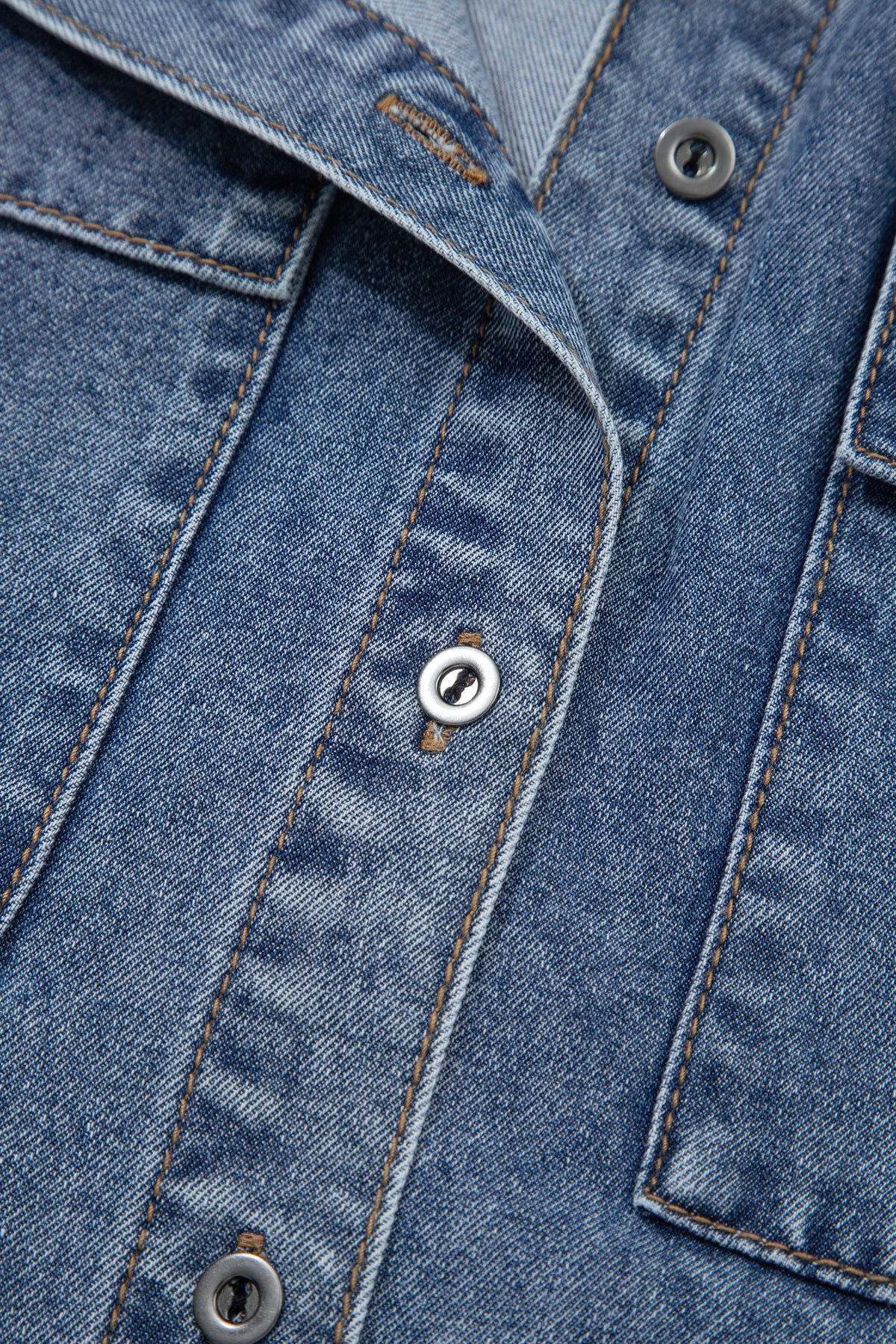 Détails chemisier en jean bleu : boutons pression, surpiqûres et poche poitrine