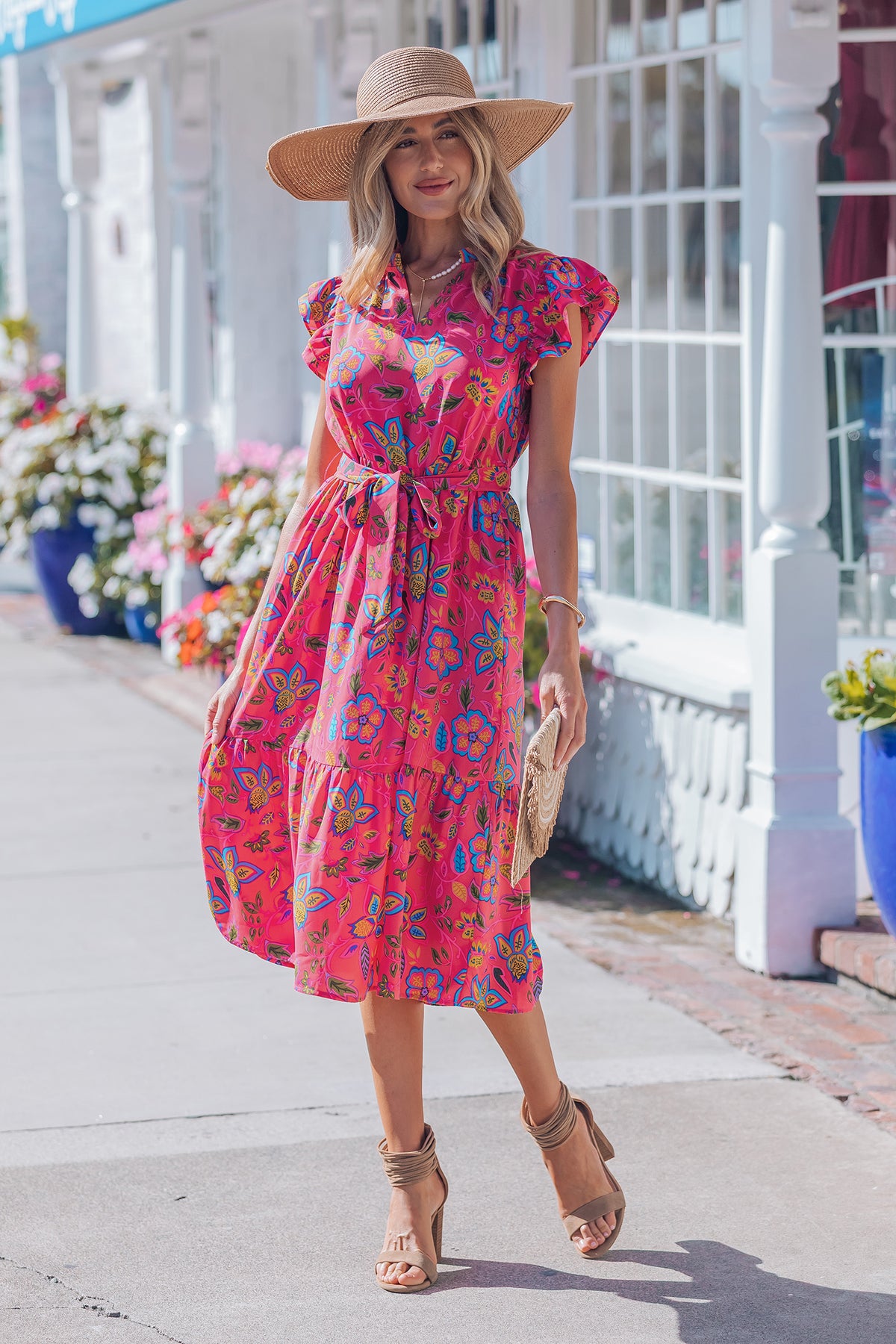 Robe mi-longue fuchsia fleurie, ceinture à nouer, manches volantées, coupe évasée.