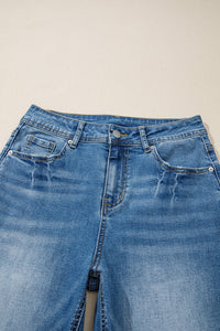 Jean taille haute bleu myosotis, ceinture avec passants et boutons à rivets.
