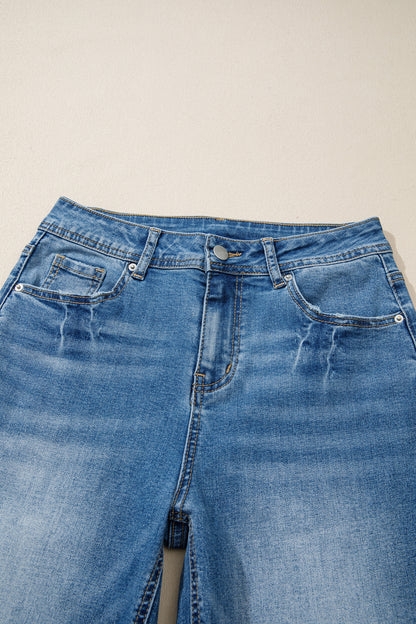 Jean taille haute bleu myosotis, ceinture avec passants et boutons à rivets.