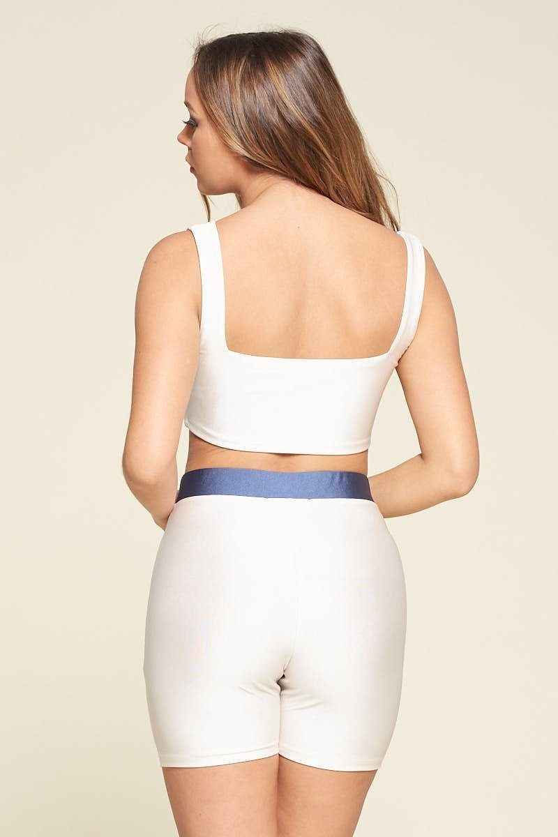 Ensemble deux pièces blanc de dos : brassière à dos carré et short, bande bleue.