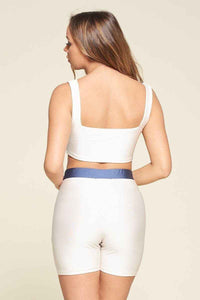 Ensemble deux pièces blanc de dos : brassière à dos carré et short, bande bleue.