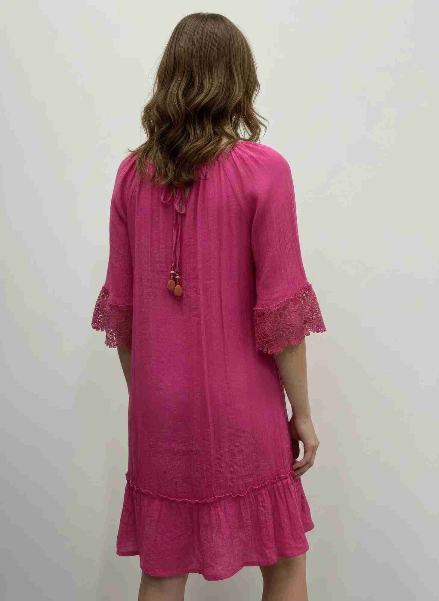 Robe rose vue de dos, cordon à l’encolure, dentelle crochet aux manches, volant