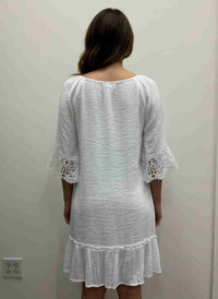 Robe blanche vue de dos, encolure dégagée, dentelle crochet aux manches, volant
