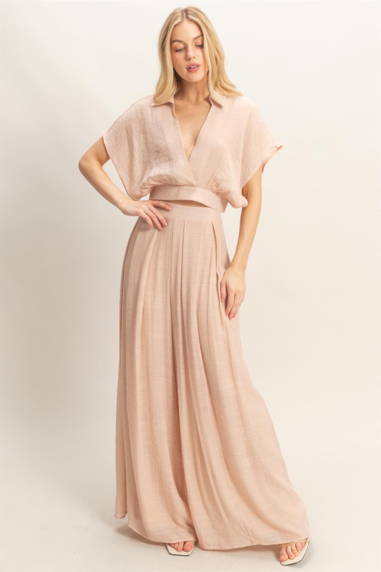 Ensemble deux pièces rosé : haut cache-cœur et pantalon ample fluide.