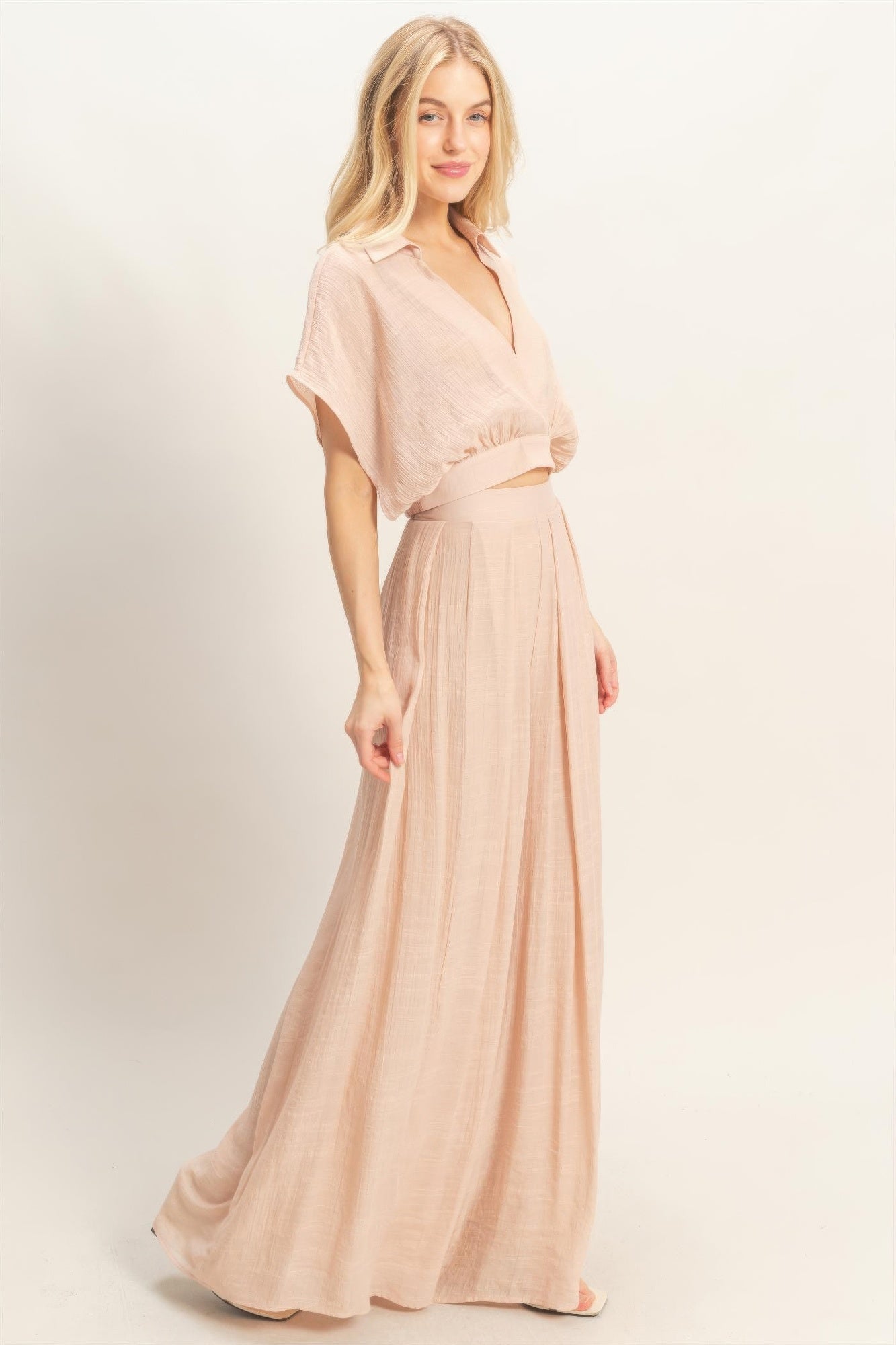 Ensemble deux pièces rosé porté de face : haut cache-cœur et pantalon long ample.