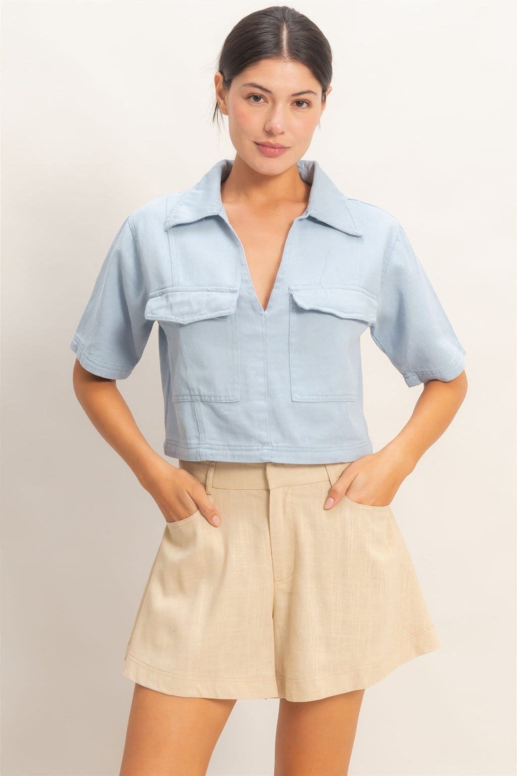 Haut femme en coton bleu ciel, col V, manches courtes, poches plaquées devant.