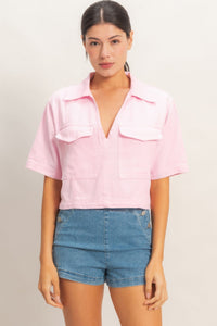 Haut col V structuré rose pâle, manches courtes, poches poitrine et fermeture boutonnée