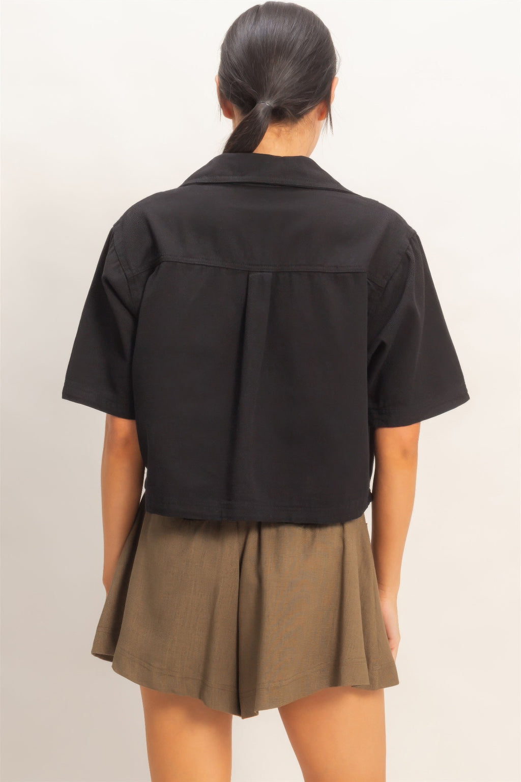 Haut femme en coton noir, dos uni, manches courtes, coupe structurée.