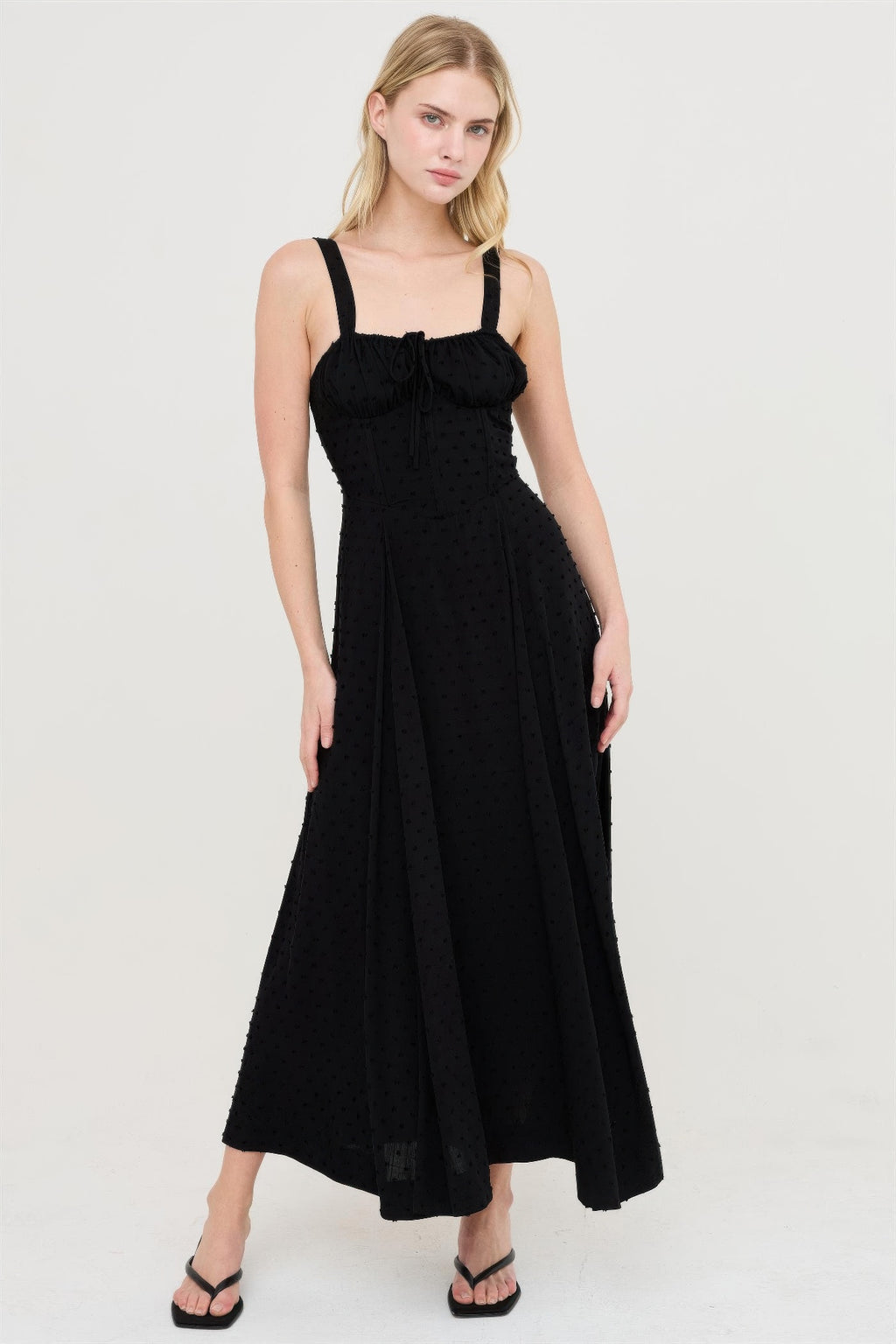 Robe noire à bretelles fines, encolure carrée froncée, jupe évasée fendue
