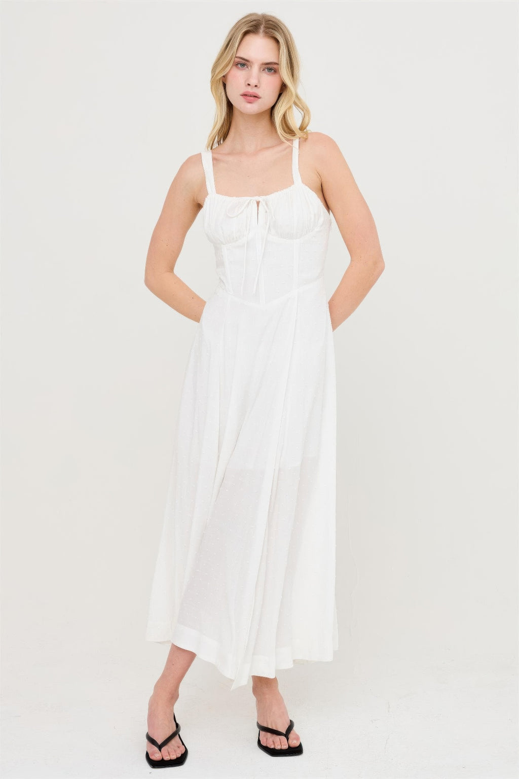 Robe blanche cassé à bretelles fines, corsage smocké, jupe évasée avec fente