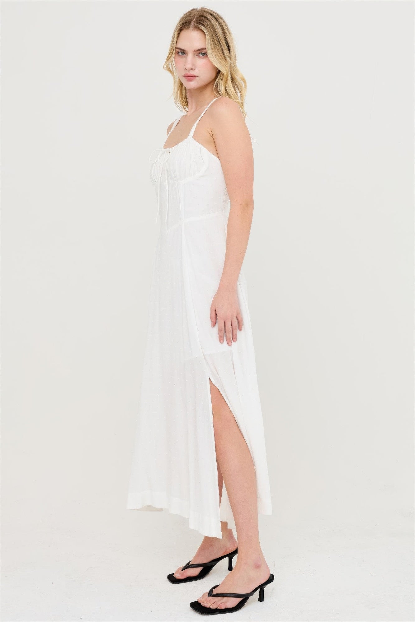 Robe blanche cassé à bretelles, jupe longue fendue, coutures verticales