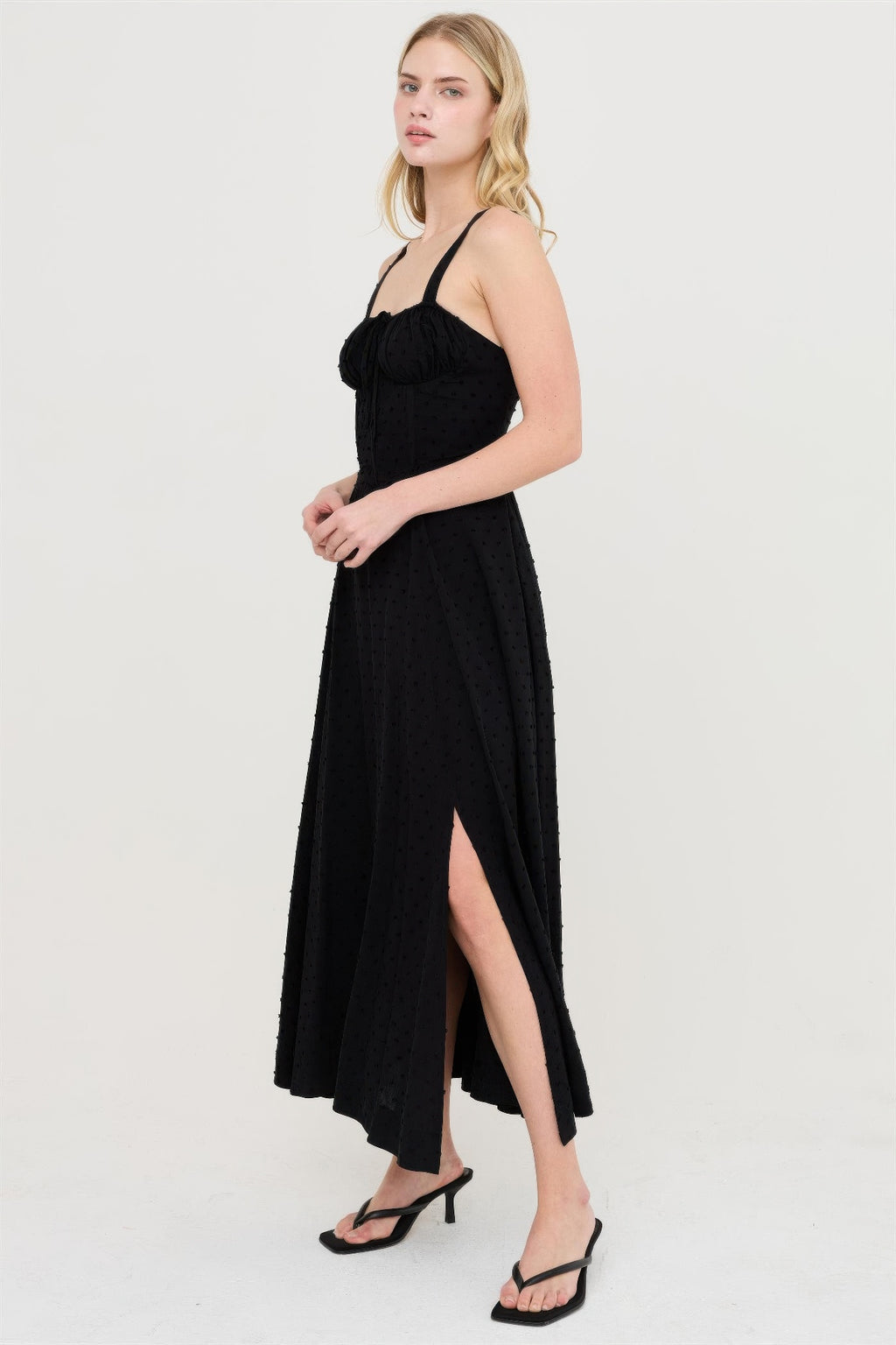 Robe noire à bretelles, décolleté carré, jupe fendue sur le côté